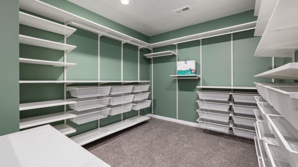 Spacious walk-in closet featuring modern white shelving and ample storage space.