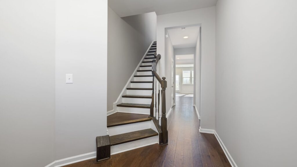 Contemporary hallway with wooden flooring and sleek staircase, perfect for modern homes.