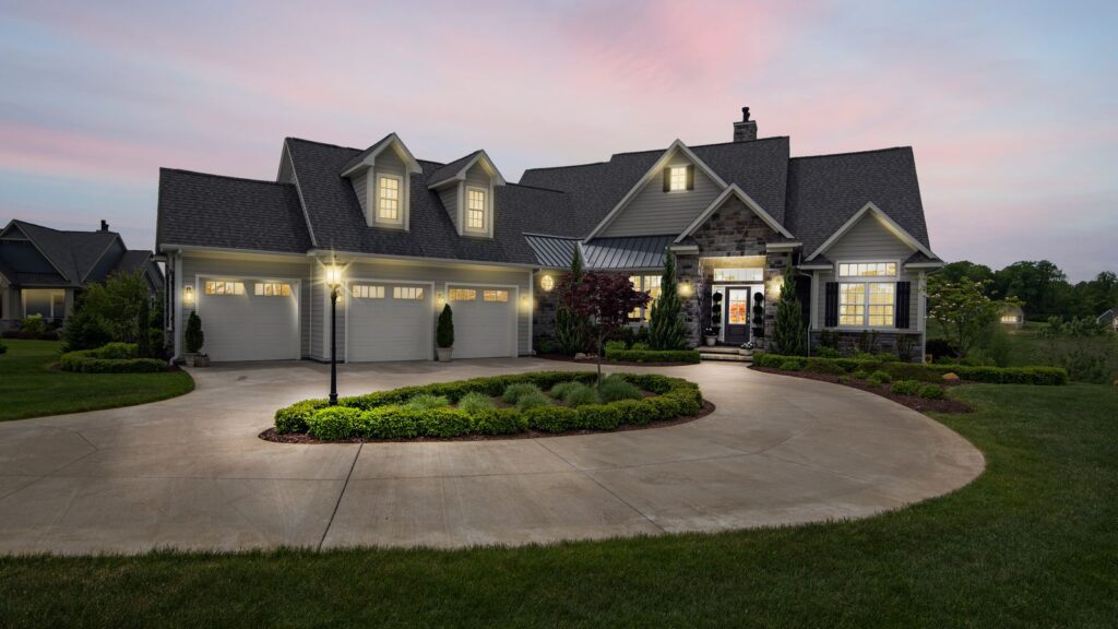 A modern suburban home at dusk, beautifully lit with exterior lights.